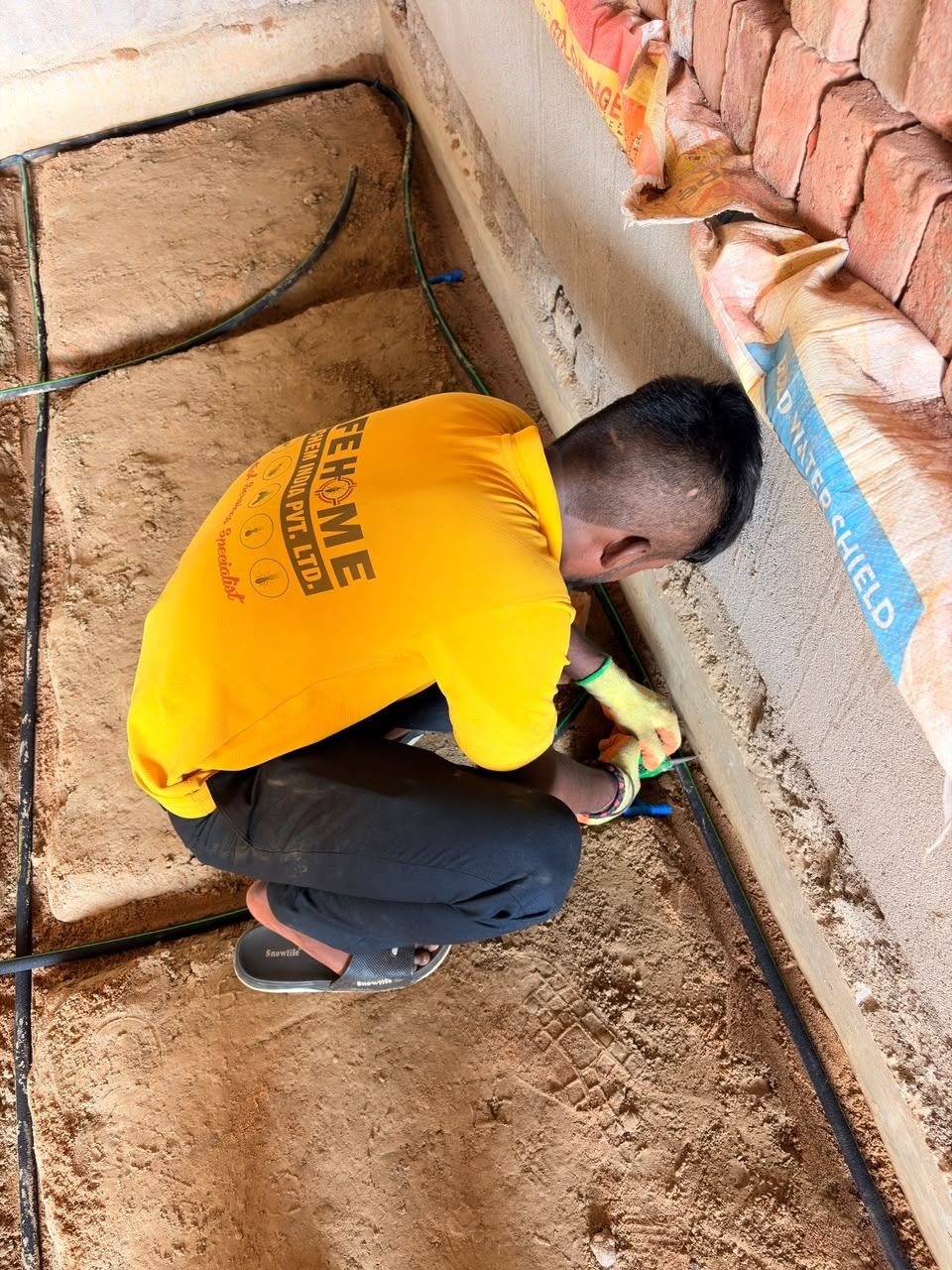 Safe Home Pestochem technician installing porous pipe termite reticulation in a foundation trench